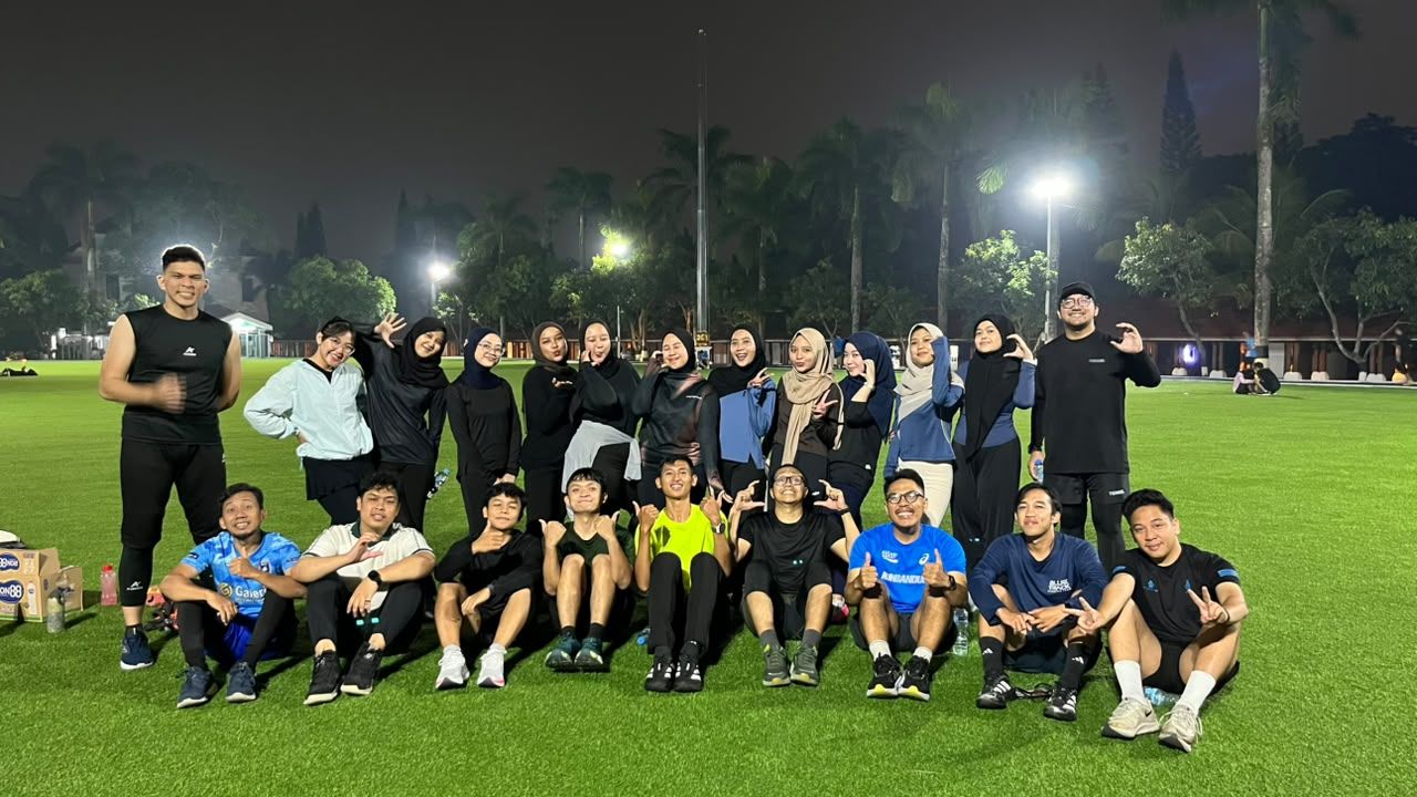 Tim CRK berfoto bersama di lapangan rumput malam hari